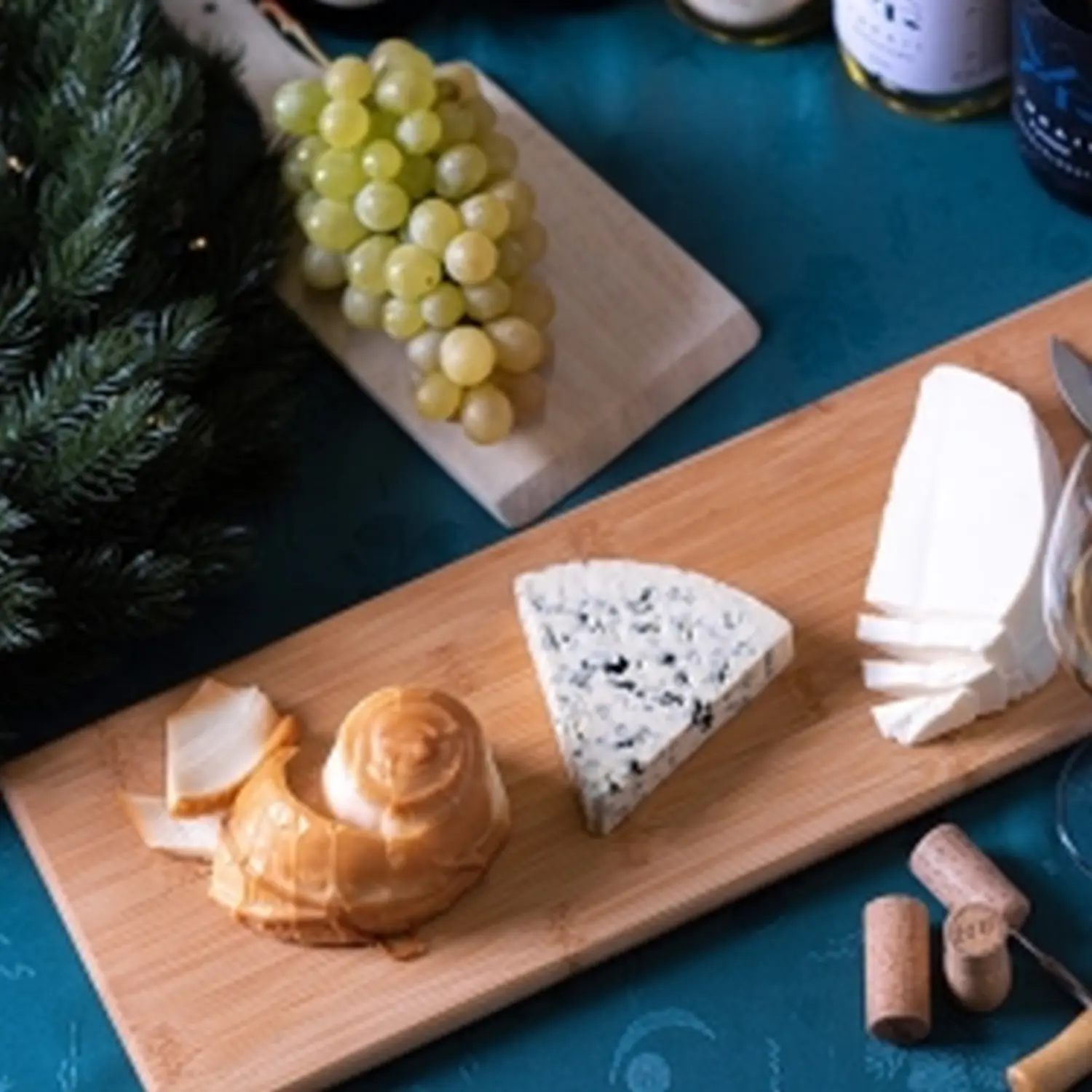 Käse, Brot, Trauben auf Holzbrett