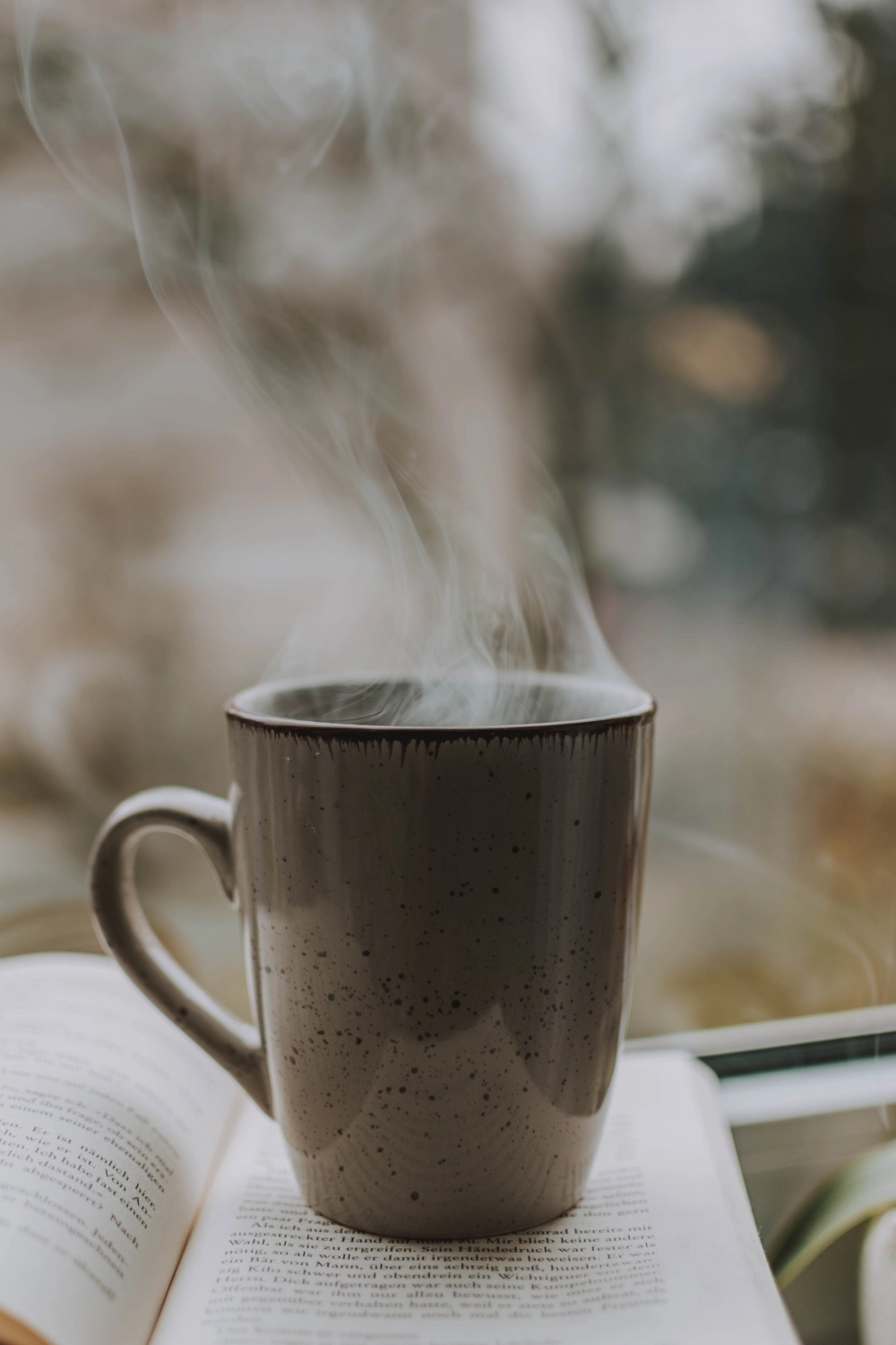 Rauch kommt aus einer Kaffeetasse und einem Buch